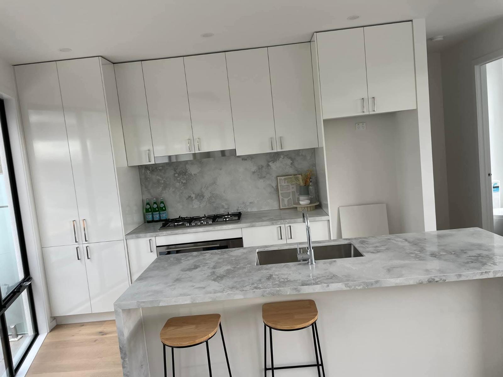 Gloss white kitchen with stone island and pendant lighting
